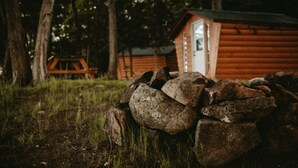 Eine rustikale Holzhütte mit Holzfassade, einer Tür und einem kleinen Fenster.