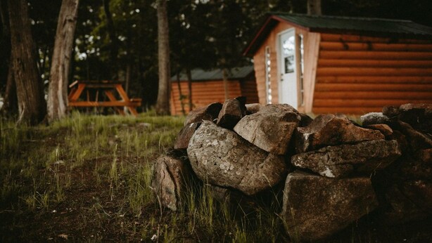 A rustic cabin with a wooden exterior, a door, and a small window.