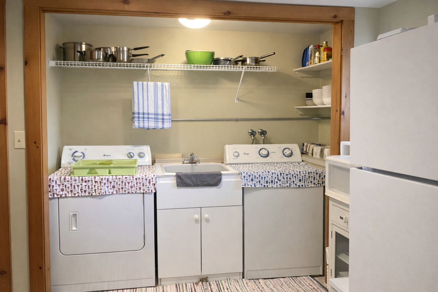 A compact kitchen with a washing machine, a stove, and a refrigerator.