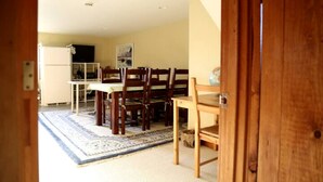 Un coin repas avec une table et des chaises, un réfrigérateur et un tapis.
