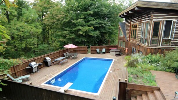 Un jardin avec une piscine, du mobilier de jardin et une terrasse en bois.
