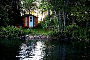 A cabin by a lake surrounded by trees. - Couples Glamping Cabin for Nature Getaway on Golden Lake (Killaloe)