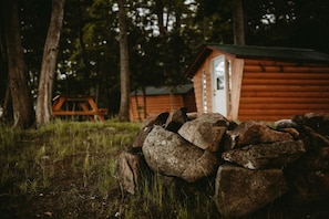 A rustic cabin with a wooden exterior, a door, and a small window.