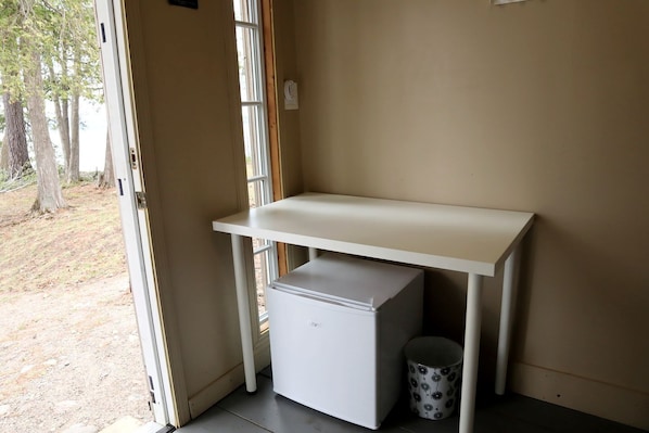 A white desk with a small storage unit and a patterned mug.