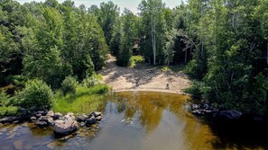 A natural landscape with a pond, trees, and a bench. - Golden Lake Glamping Cabin for an Outdoor Adventure in Killaloe, Ontario (Killaloe)