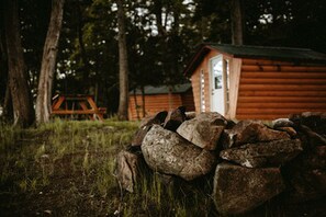 Ein rustikales Blockhaus mit Holzwänden, einer Tür und einer kleinen Veranda.