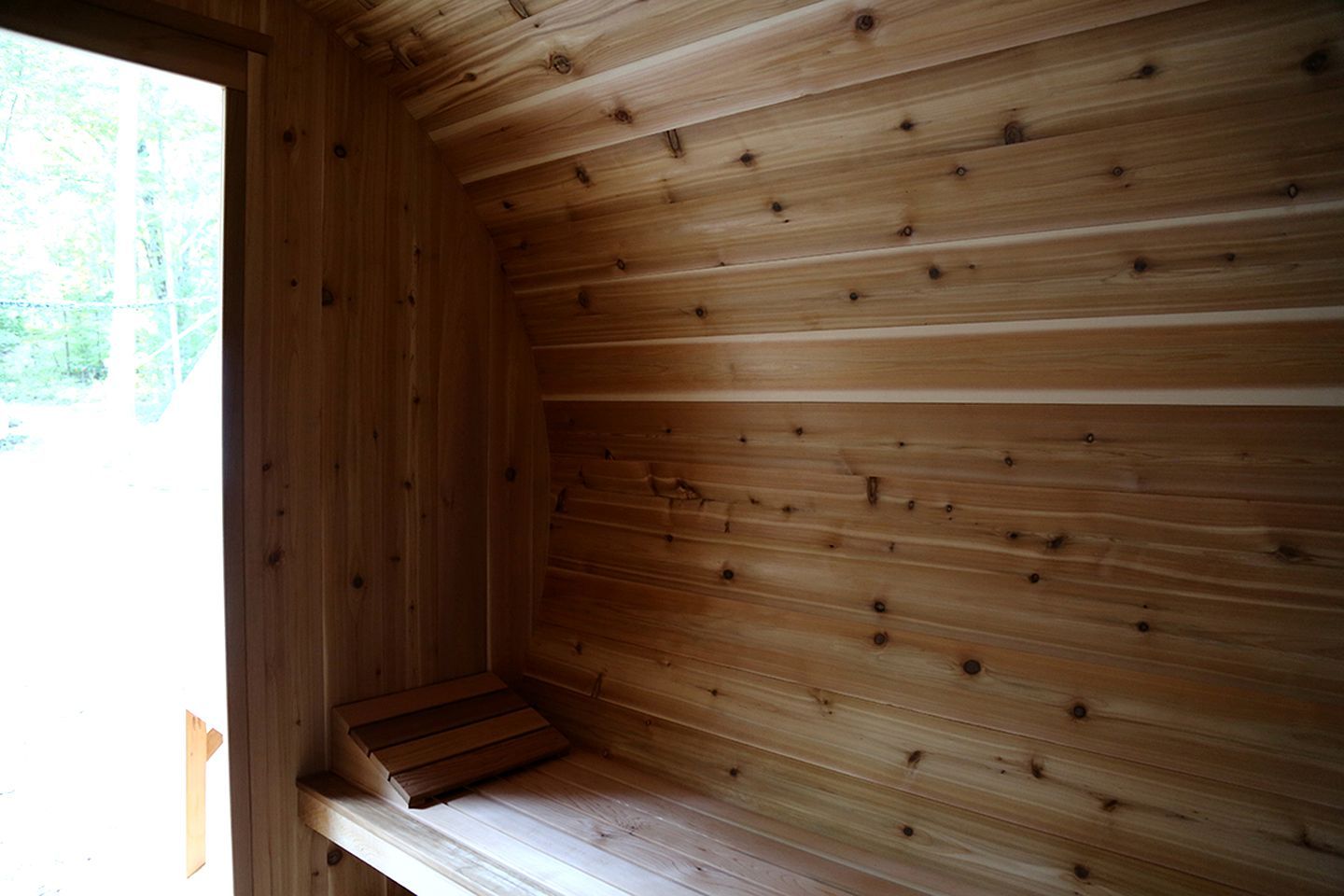 A wooden interior with a bench and a window.