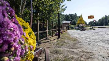 A campground with a wooden fence, flower beds, and a sign for a coffee bar and gifts.