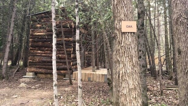 A log cabin surrounded by trees with a sign reading 'OAK'. - Rustic Cabin Incredible for Hiking and Outdoor Lovers in Ontario (Markdale)