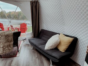 A cozy outdoor seating area with a sofa, chairs, and a rug.