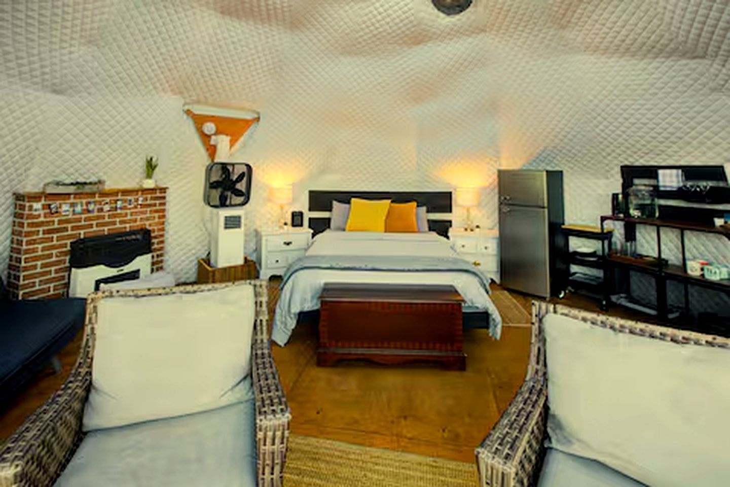 Une chambre confortable avec un lit, une petite table, une chaise, une bibliothèque et une cheminée.