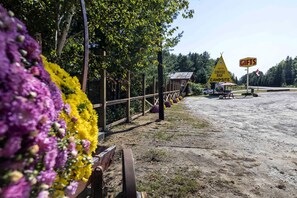 A campground with a wooden fence, flower beds, and a sign for a coffee bar and gifts.