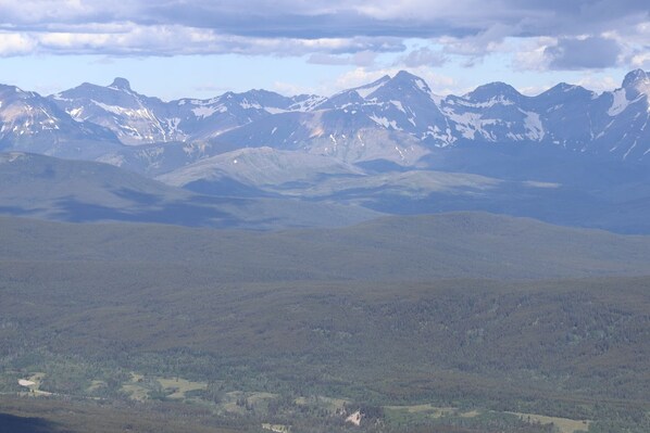 A mountainous landscape with a valley and forested area.
