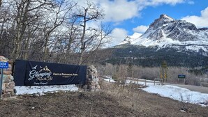 A sign for Glamping Resorts Ltd in Castle Provincial Park with a mountain backdrop.