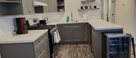Fridge, dishwasher, coffee/tea maker, cookware/dishes/utensils