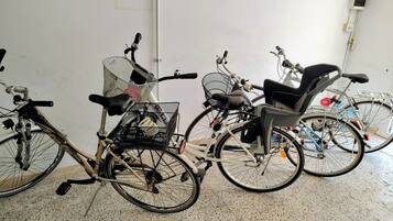 En cykel med en korg och ett barnstol som står parkerad inomhus.