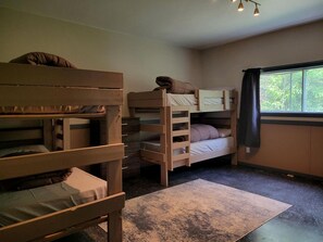 Ein Schlafsaalzimmer mit einem Fenster, einem Schreibtisch und einem Stuhl.