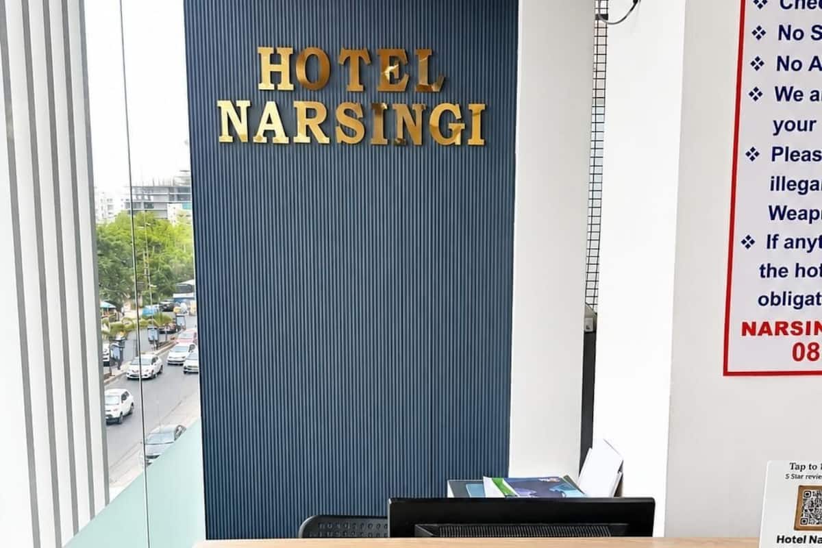 A hotel reception desk with a view of the street outside.