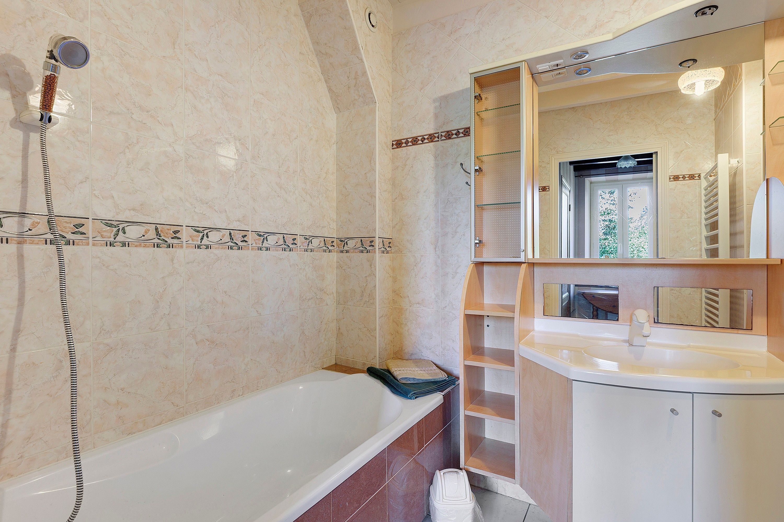 Une salle de bain équipée d’une baignoire, d’une douche et d’un meuble-lavabo avec un miroir.