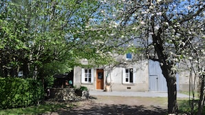 A building with a door, windows, and a blue gate. - Holiday Home “La Charmille” with Private Terrace and Garden (Nouzerolles)
