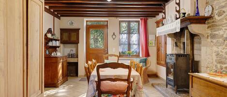 A traditional dining room with a wooden table, chairs, and a fireplace.