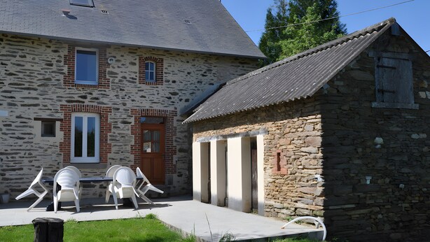 A stone building with a large window, a door, and a small attached structure with a sloped roof. - Holiday Home “La Charmille” with Private Terrace and Garden (Nouzerolles)