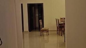 Een ruime kamer met een betegelde vloer en een eethoek met houten stoelen en een tafel.