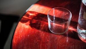 Ein Glas Wasser auf einem roten Tisch.
