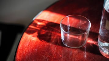 Un verre d’eau sur une table rouge.