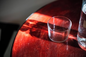 A glass of water on a red table. - Margherita Home (Reggio nell'Emilia)