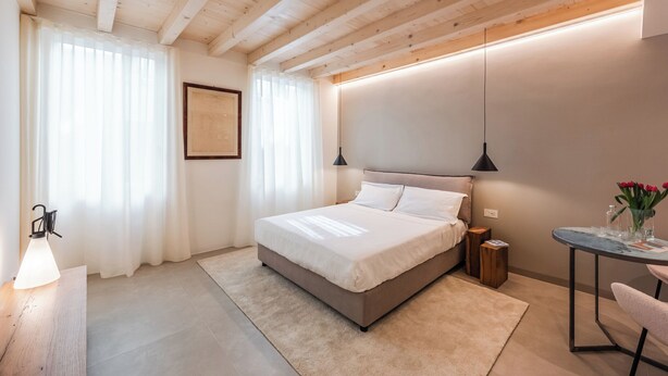 Ein Schlafzimmer mit einem Bett, Nachttischen, einem Schreibtisch und einer Lampe.