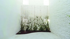 Un espace étroit et clos, avec un mur en briques blanches et une structure en forme de grille.