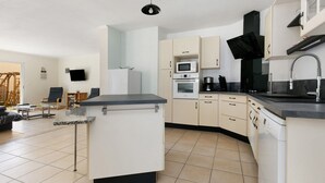 A modern kitchen with a central island, built-in microwave, oven, and dishwasher. - Family House with 4 Bedrooms for 13 Guests (La Plaine-sur-Mer)