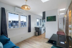 Eine moderne Wohnung mit Wohnzimmer, Küche und Blick auf die Stadt.