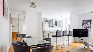 A modern apartment with a dining area, kitchen, and living space. - Mobility Lease - Porte Dauphine - 1 large bedroom (Paris)