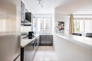 Eine moderne Küche mit Backofen, einer Kaffeemaschine und einem Fenster mit Blick auf Gebäude.