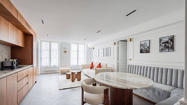 A modern living room with a marble coffee table, a sofa, and a dining area. - Luxurious 2 Bedrooms - Le Marais - Paris 3 # AC (Paris)
