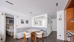 A room with a round table, two chairs, a bench, and a bed. - Luxurious 2 Bedrooms - Le Marais - Paris 3 # AC (Paris)