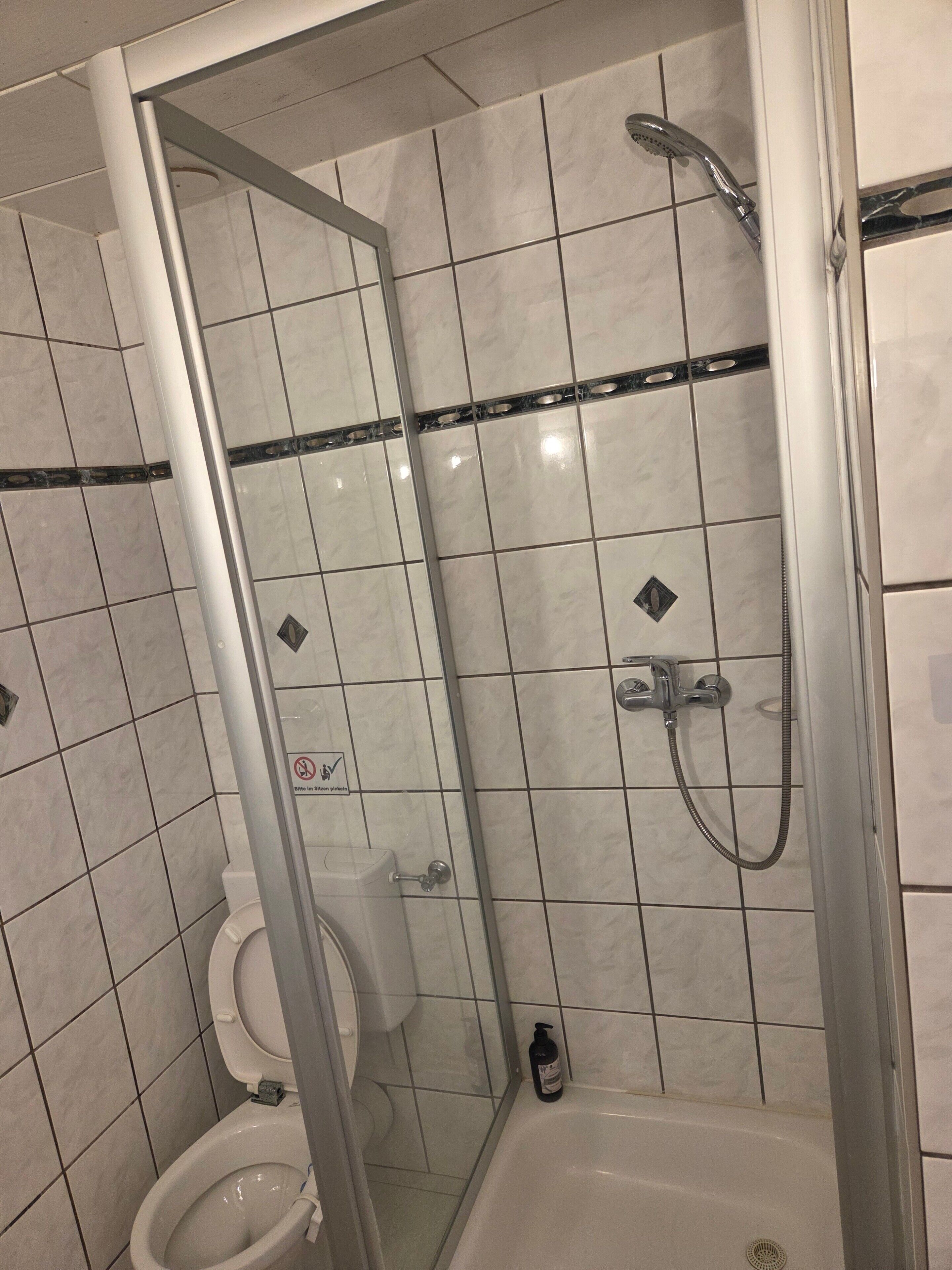 Un bany amb vàter, plat de dutxa i banyera.