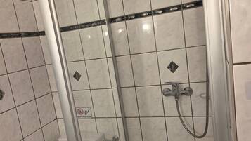 Un bany amb vàter, plat de dutxa i banyera.