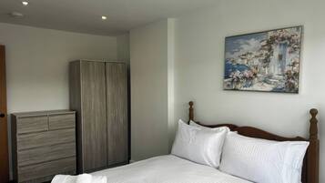 Habitación de hotel con cama, armario y un cuadro en la pared.