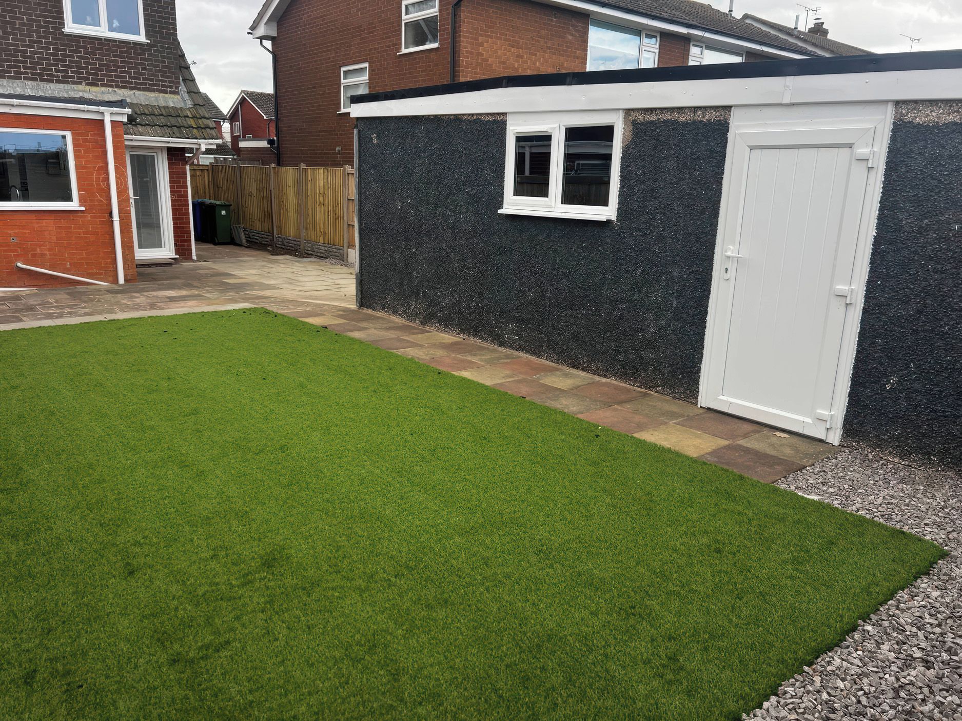 A residential property with a well-maintained lawn, a garage, and a brick house.