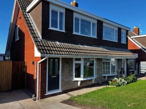 A two-story residential house with a tiled roof, a front porch, and a fenced yard. - 21 Bastion Gardens (Prestatyn)