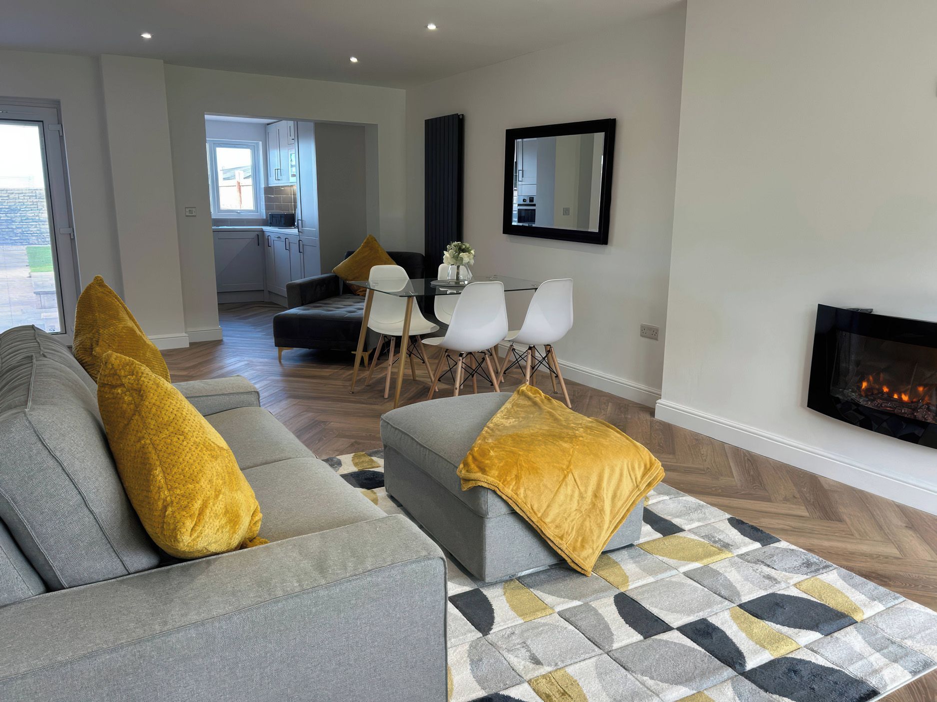 A modern living room with a grey sofa, a coffee table, and a fireplace.