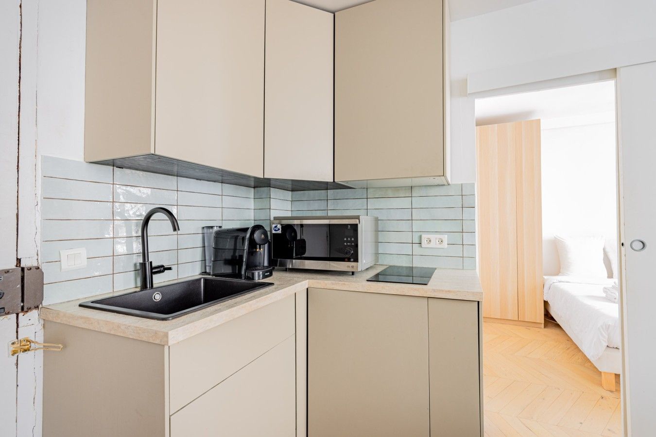 A compact kitchenette with a sink, coffee maker, and microwave.