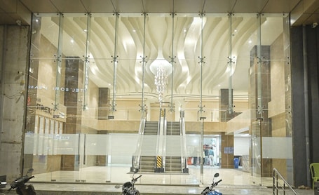 A modern building with glass walls, a central staircase, and a chandelier.