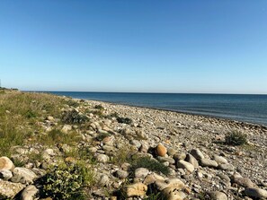 Ein felsiger Strand mit freiem Blick auf das Meer.