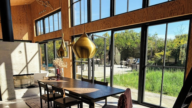 A modern dining area with a large table, chairs, and pendant lighting. - Creative summer house 200 metres from beach (Sjællands Odde)