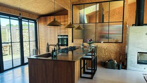A modern kitchen with a central island, pendant lighting, and large windows. - Creative summer house 200 metres from beach (Sjællands Odde)
