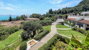 A residential area with terraced houses, a pathway, and a view of the sea. - Charming apartment in quaint Gastouri perfect for relaxing getaway (Gastouri)